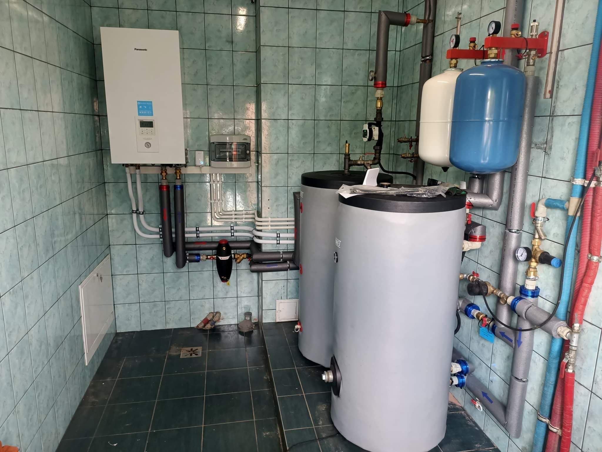 Pompa ciepła Panasonic Aquarea w retrofitowanej kotłowni — bufor, zasobnik CWU i dwa naczynia wzbiorcze na zielonej glazurze